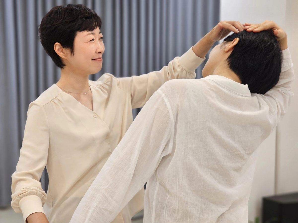 트레이너가 회원의 머리와 목을 풀어주는 브레인 체조 장면