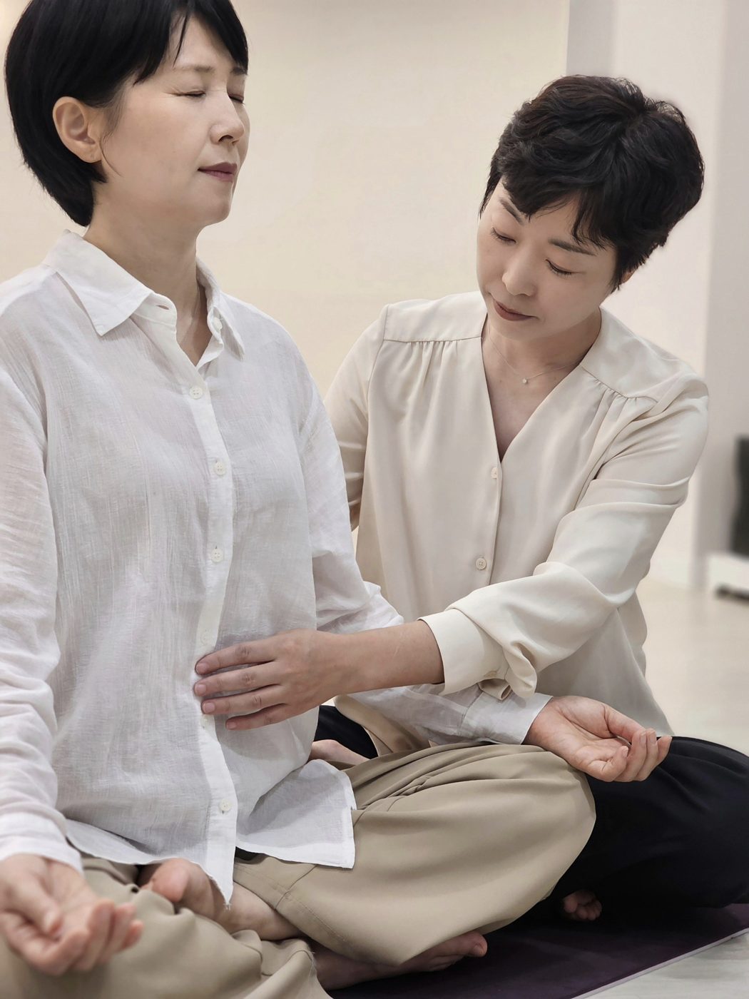 트레이너가 배에 손을 대고 호흡을 안내하는 충전 호흡